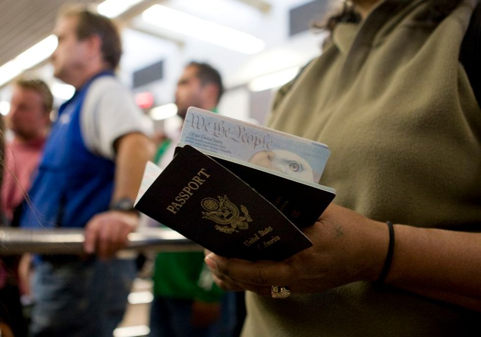 A woman holds her and her child's passport