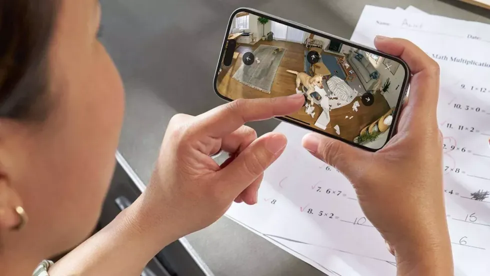 a woman holds her iphone landscape and uses on-screen controls to move the ring camera lens