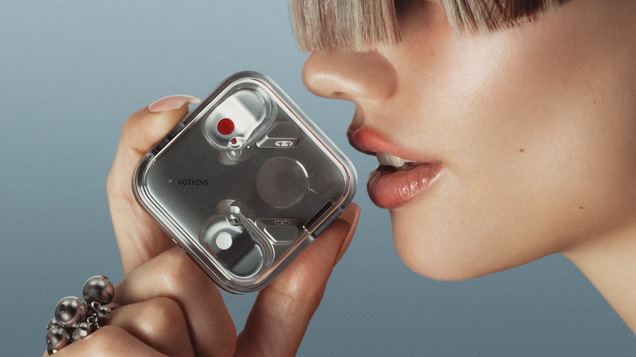 a woman holds the Nothing Ear 3 case close to her mouth