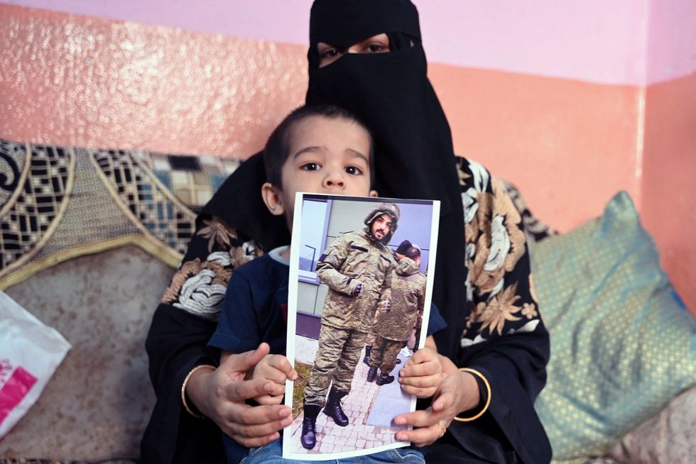 A woman in a burka holds up a picture