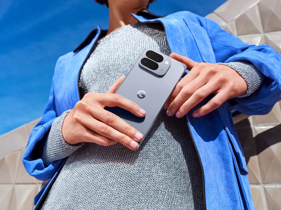 a woman in a denim jacket holds the Pixel 10 Pro Fold
