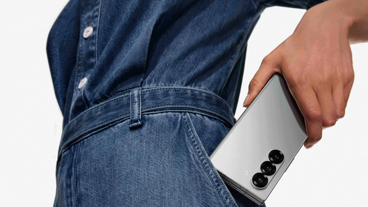 a woman in denim outfit puts the galaxy z fold 6 in her pocket