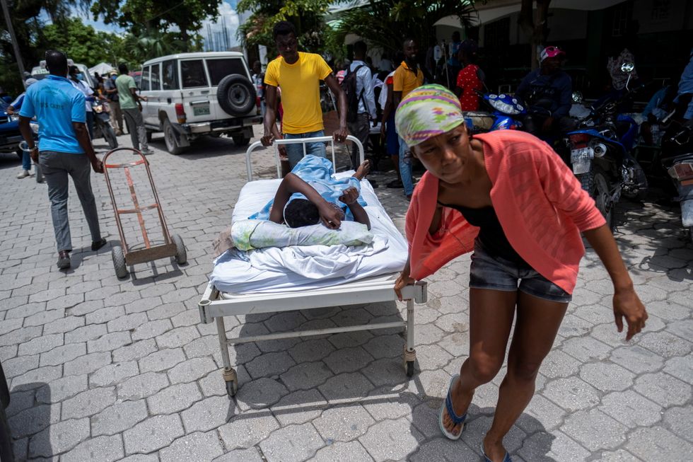 A woman injured in Saturday's 7.2 magnitude quake is transported on a hospital bed to a hospital, in Les Cayes, Haiti August 16, 2021. REUTERS/Ricardo Arduengo