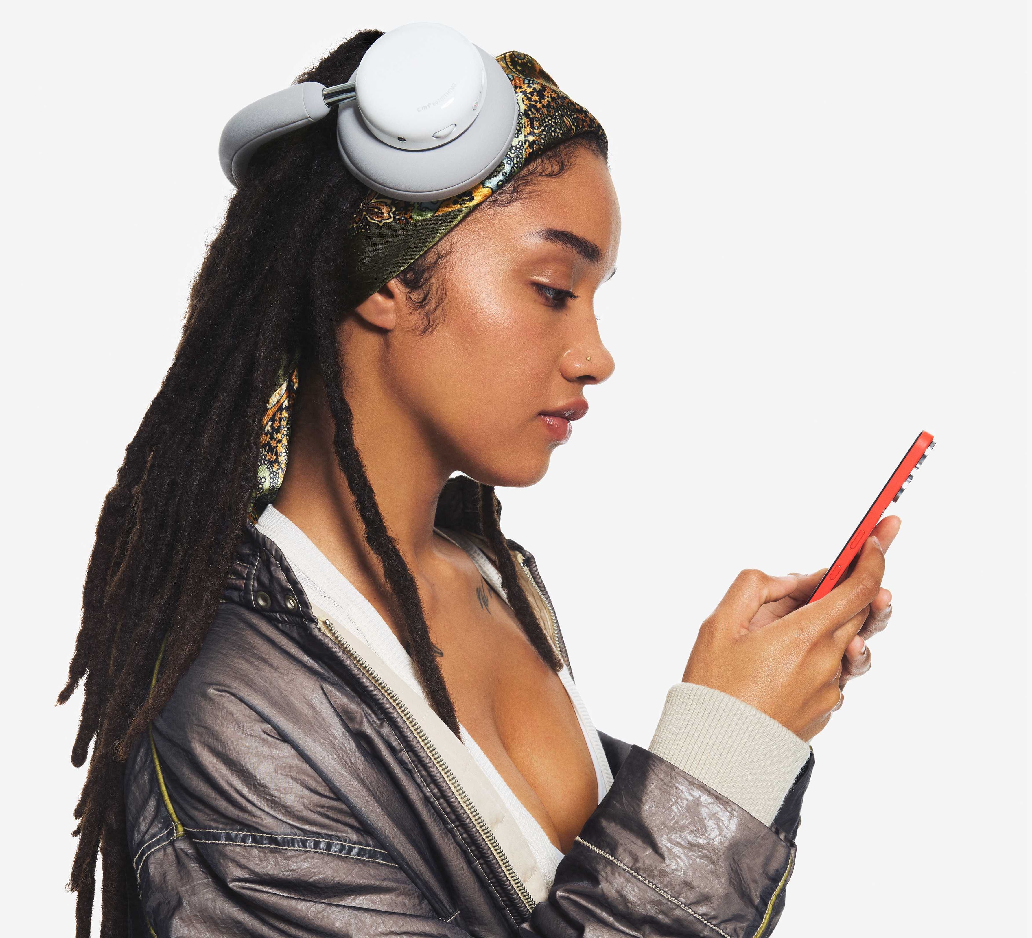 a woman models the CMF headphone pro in Light Grey using a CMF Phone