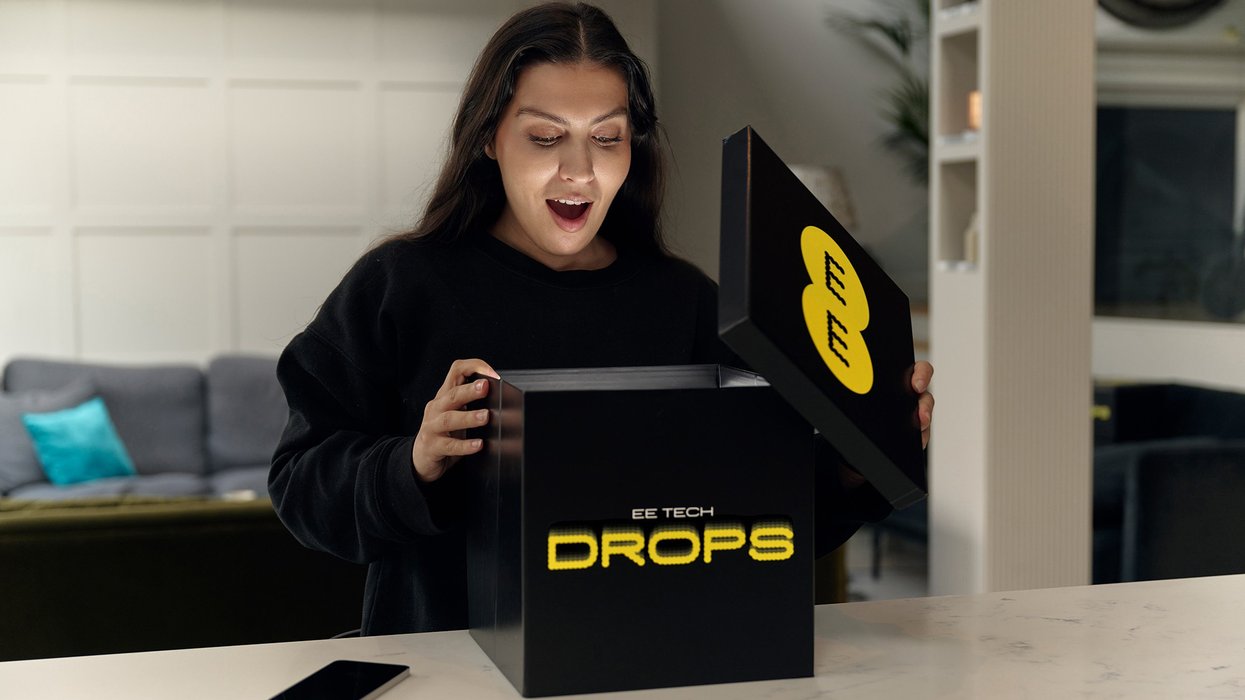 a woman opens up a box with the EE Tech Drop branding