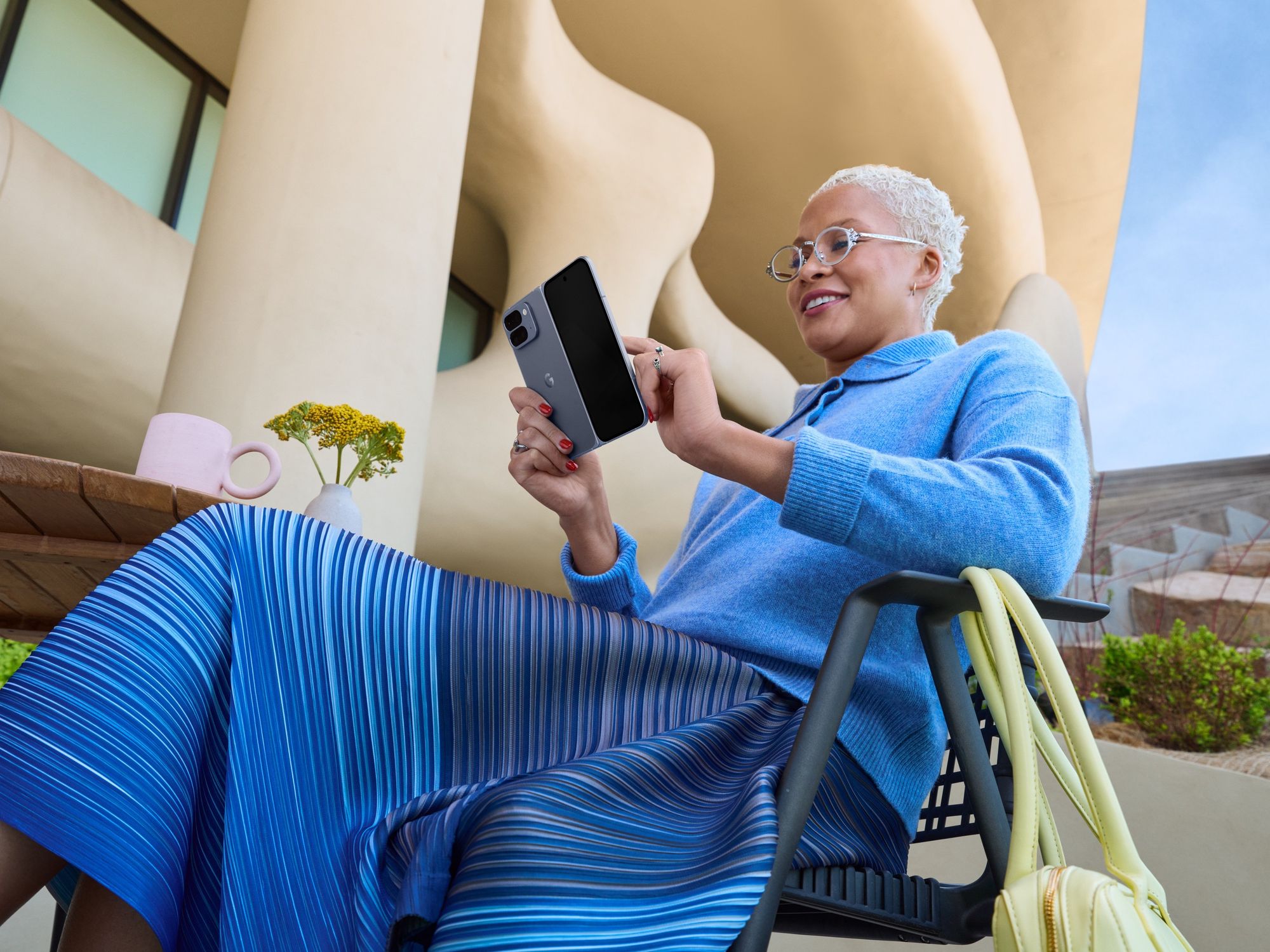 a woman reclines in a chair with the pixel 10 pro fold unfolded