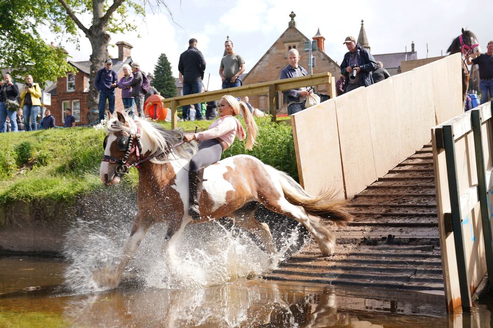 A woman rides her horse in the River Eden, on Day 2 of the Appleby Horse Fair, the annual gathering of gypsies and travellers. Picture date: Friday June 10, 2022. Photo credit should read: Owen Humphreys/PA Wire
