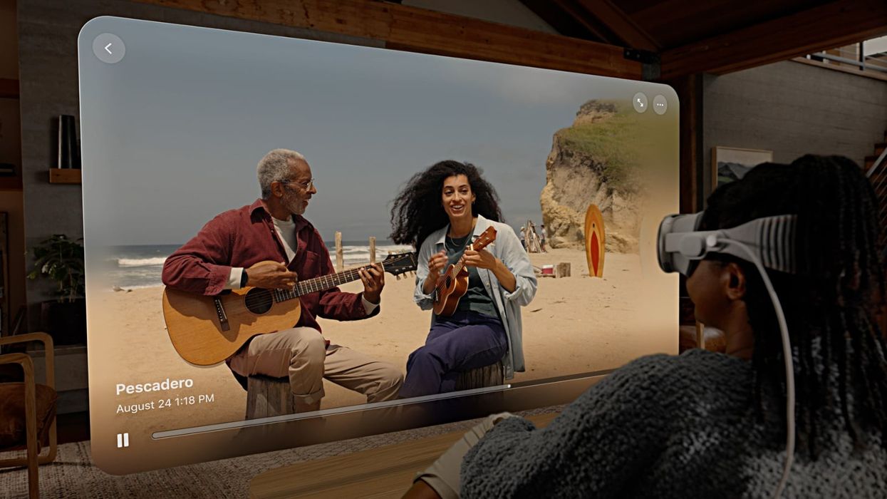 a woman sits with a vision pro watching video in spatial