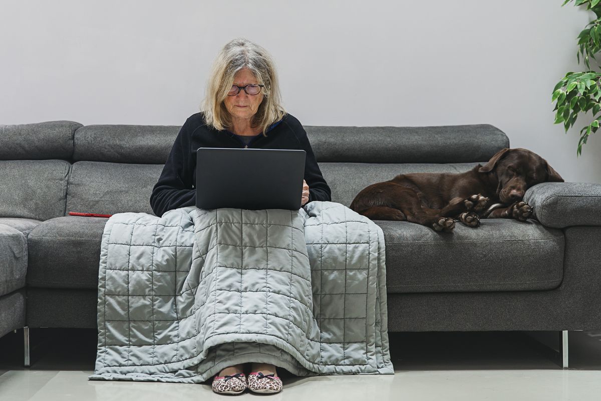 a woman sitting on a sofa using her laptop
