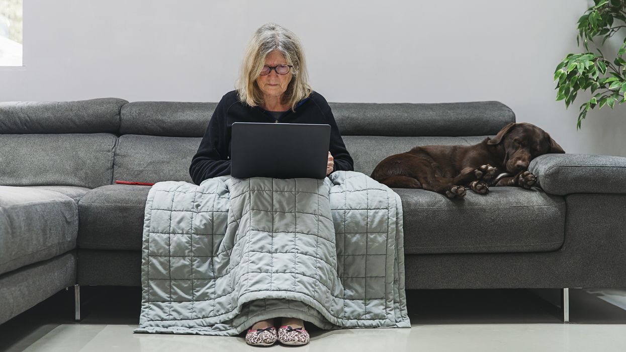 a woman sitting on a sofa using her laptop
