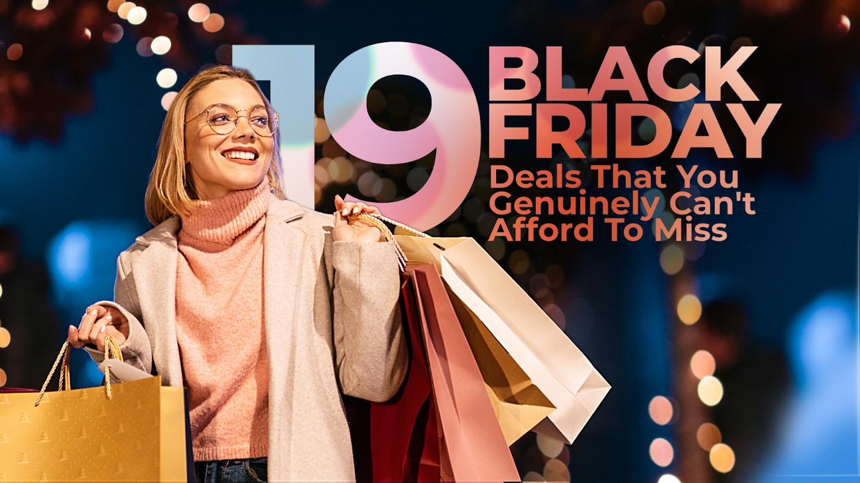 a woman smiles with shopping bags in her hands with bright christmas lights behind her