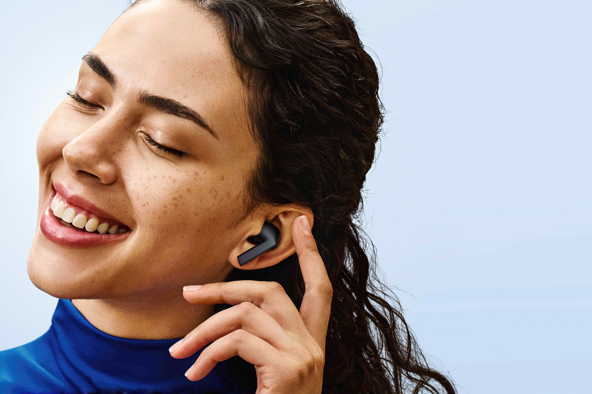 a woman smiling with a pair of galaxy buds3 FE in her ears