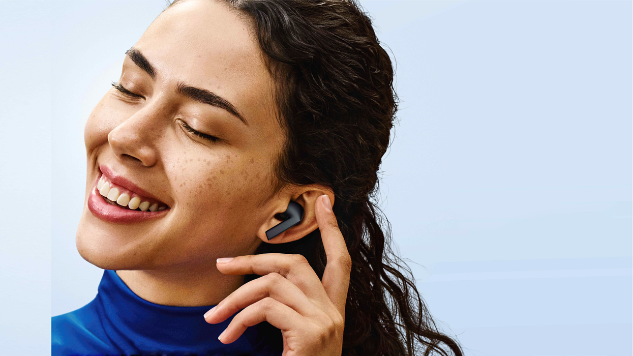 a woman smiling with a pair of galaxy buds3 FE in her ears