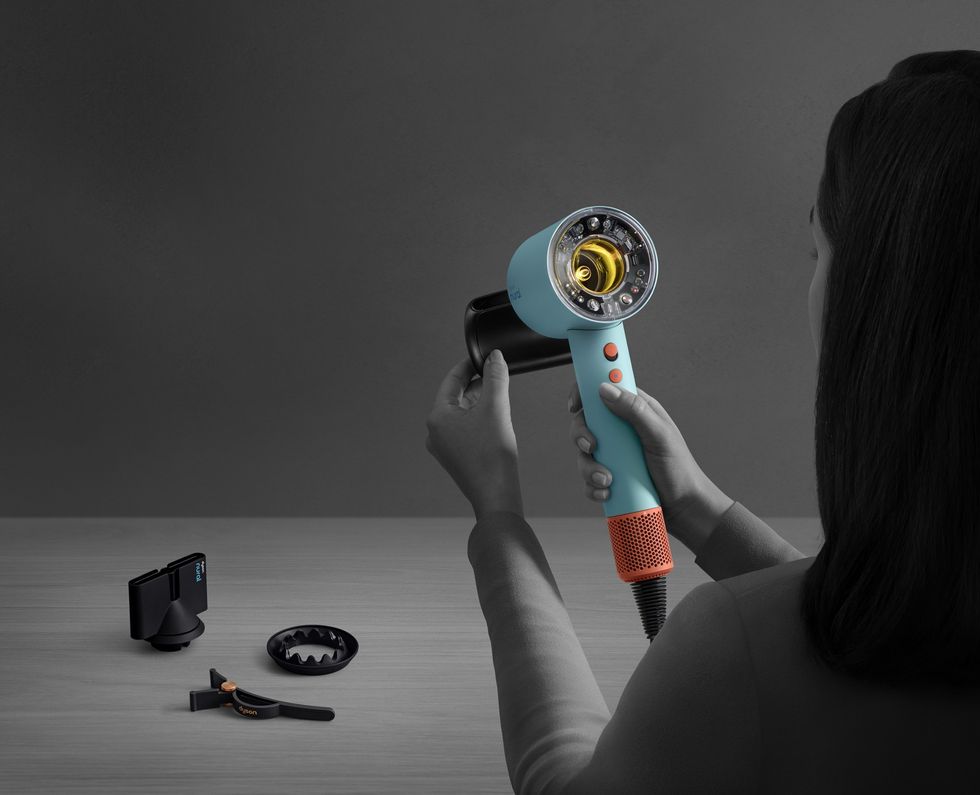 a woman snaps the flyaway attachment to the front of the supersonic nural hair dryer