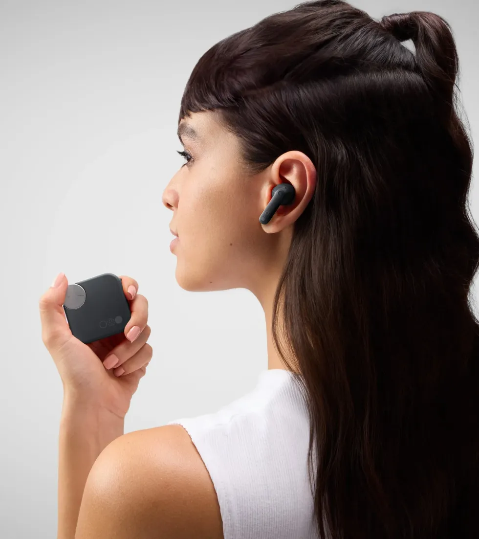 a woman spins the dial built into the charging carry case for the CMF Buds Pro 2