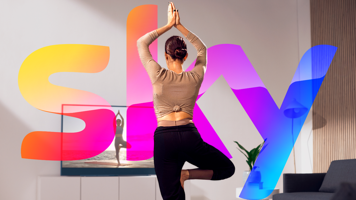 a woman stands in a yoga pose with the sky logo behind her while watching television