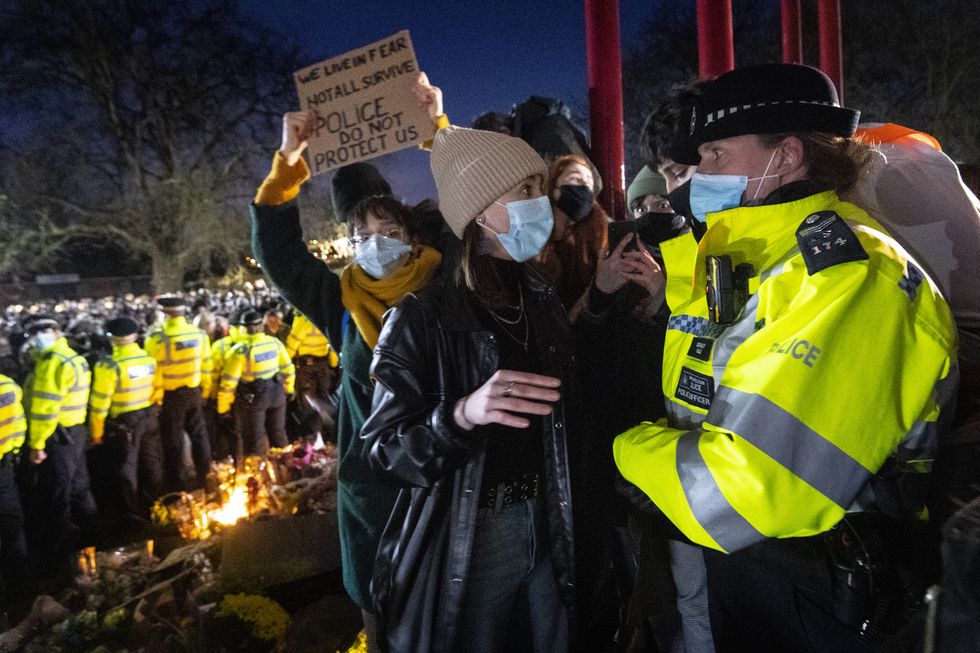 A woman talks to a police officer during a gathering in Clapham Common, London, after the Reclaim These Streets vigil for Sarah Everard was officially cancelled.