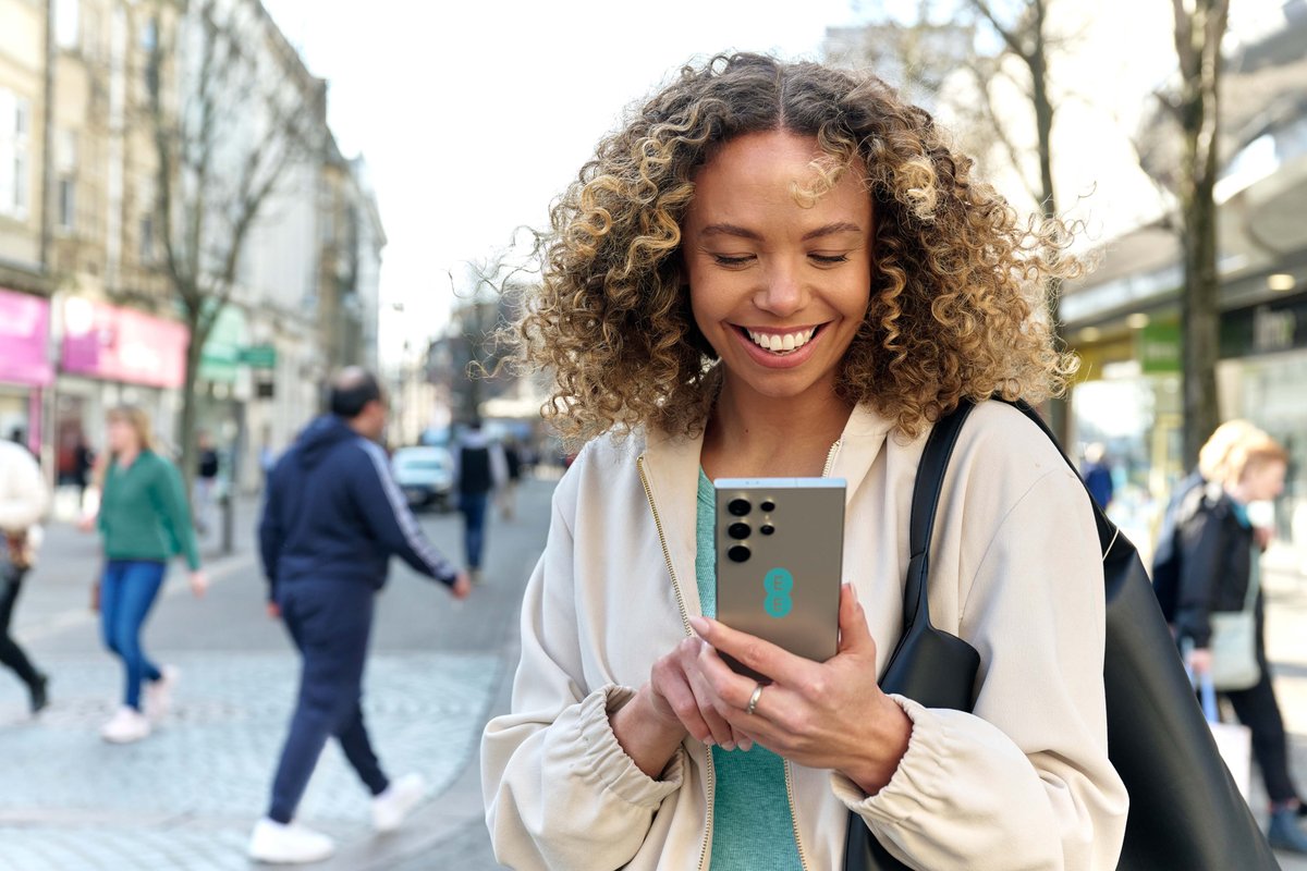 a woman uses a samsung galaxy handset with an ee sticker on the back