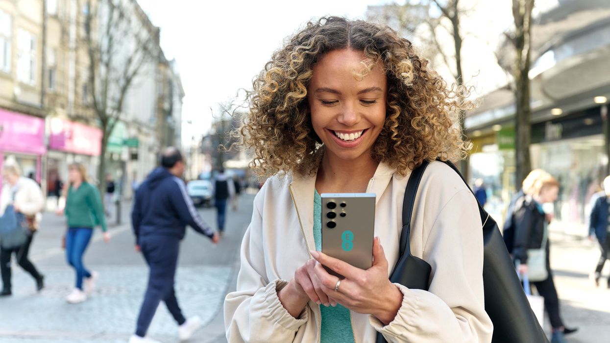 a woman uses a samsung galaxy handset with an ee sticker on the back