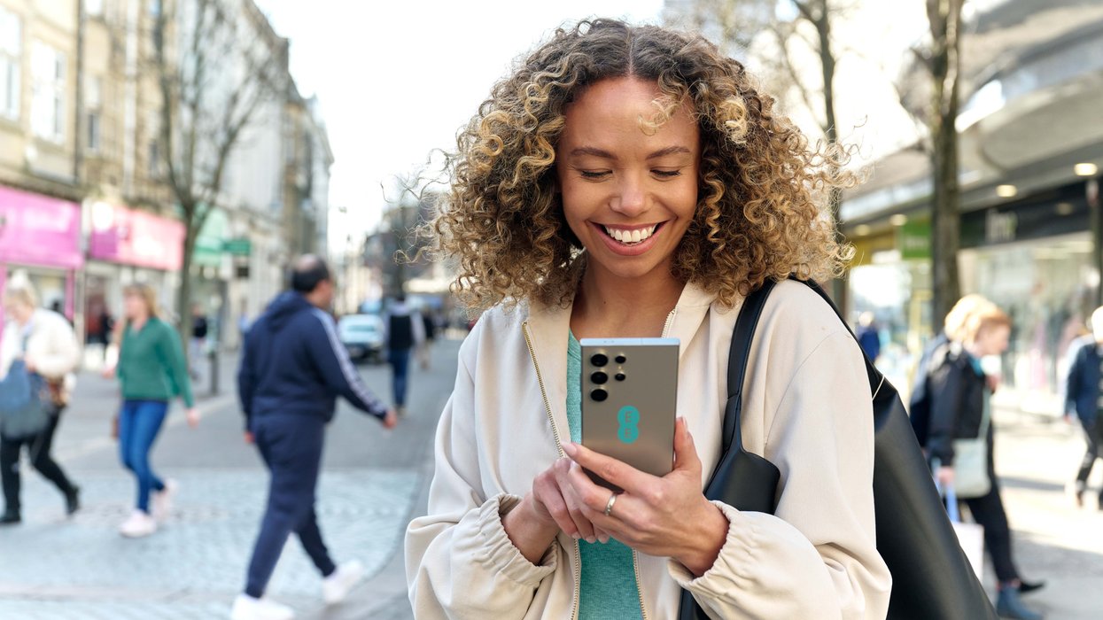 a woman uses a samsung galaxy handset with an ee sticker on the back