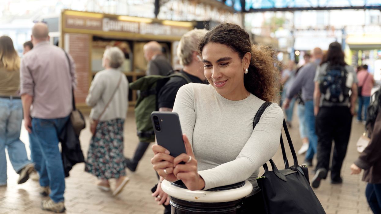 a woman uses her smartphone in a busy christmas market
