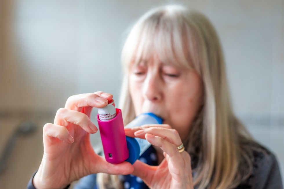 A woman using an inhaler