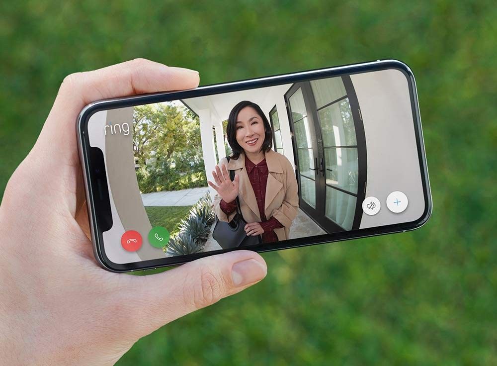 a woman waves her hand in a preview from a ring video doorbell