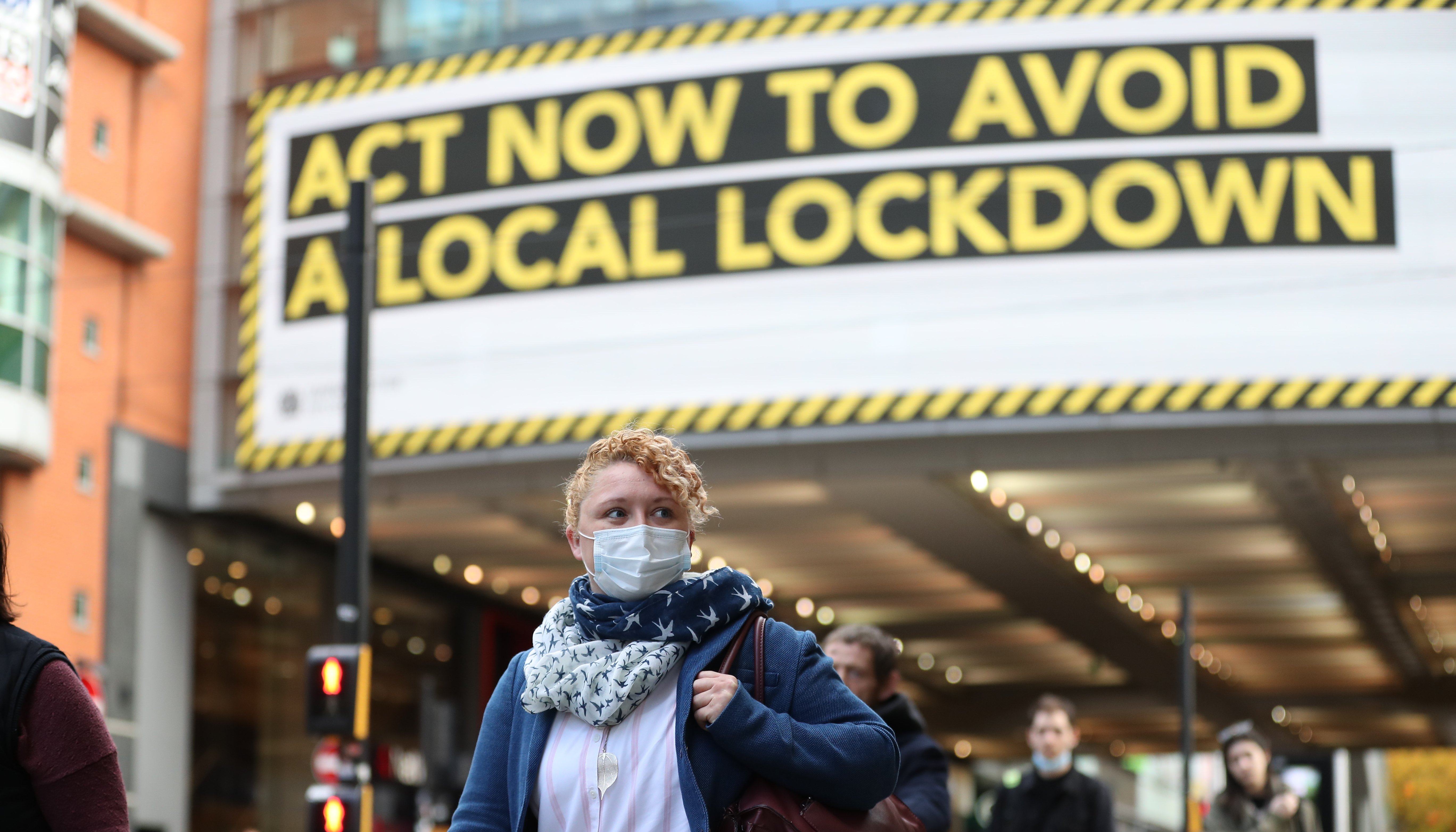 A woman wearing a face mask walks through Manchester in October 2020. Greater Manchester was placed under stricter lockdown conditions late last year due to a rise of Covid-19 cases in the region.