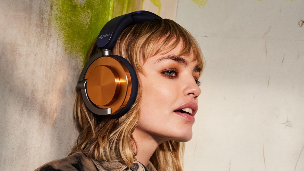 a woman wears the dyson ontrac headphones with a copper colour to the earcup
