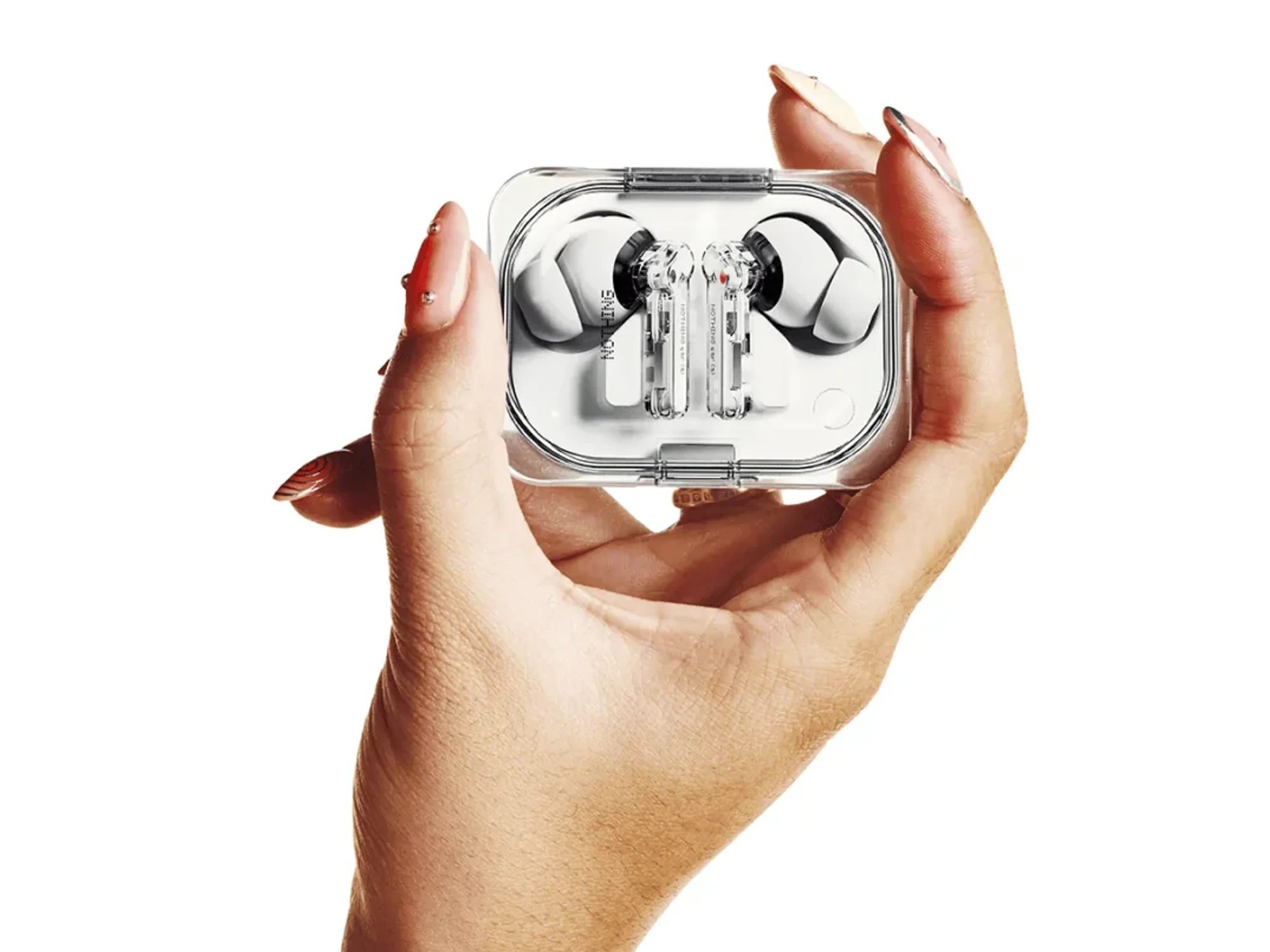 a womans hand holds the nothing ear a bluetooth earbuds in a charging case