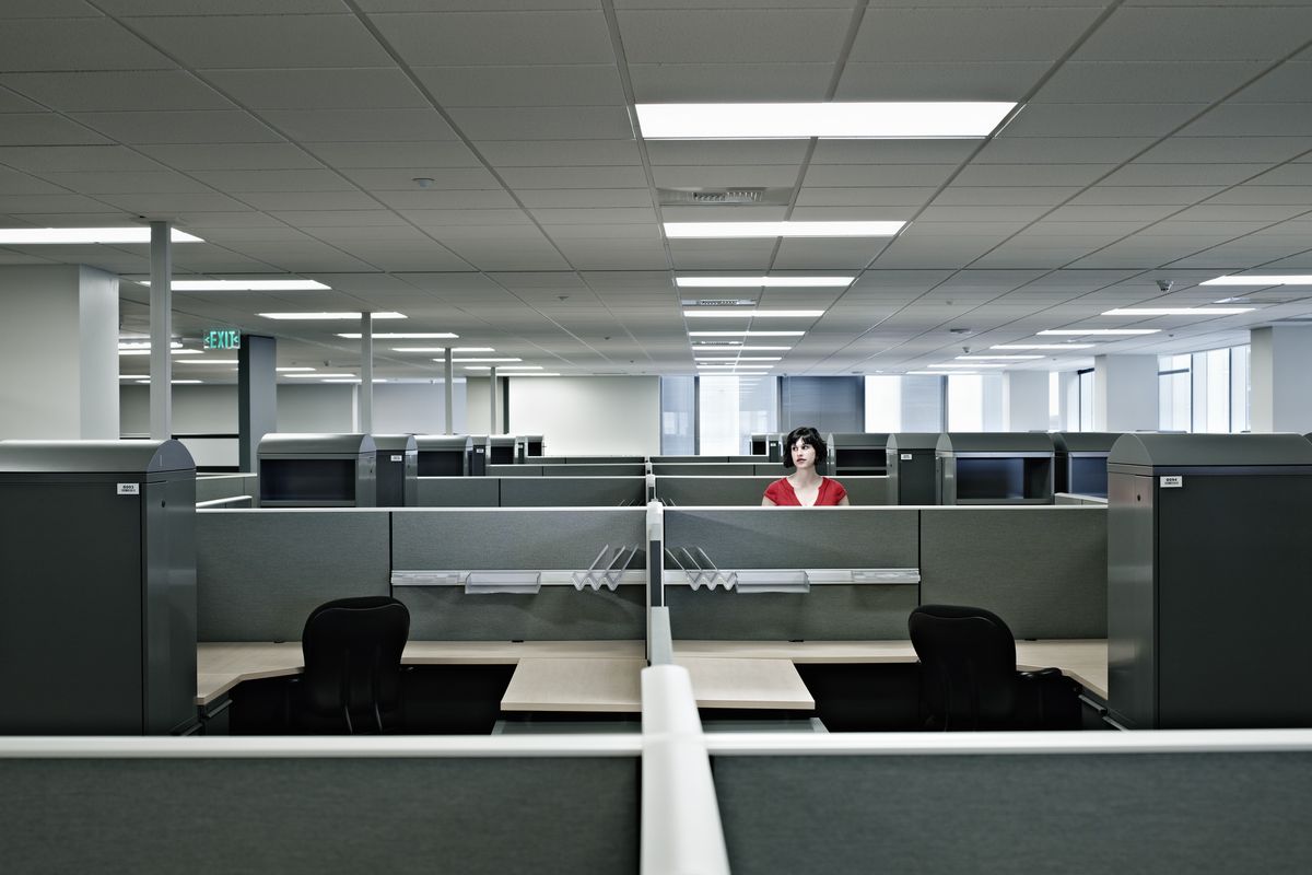 A worker standing alone in an office