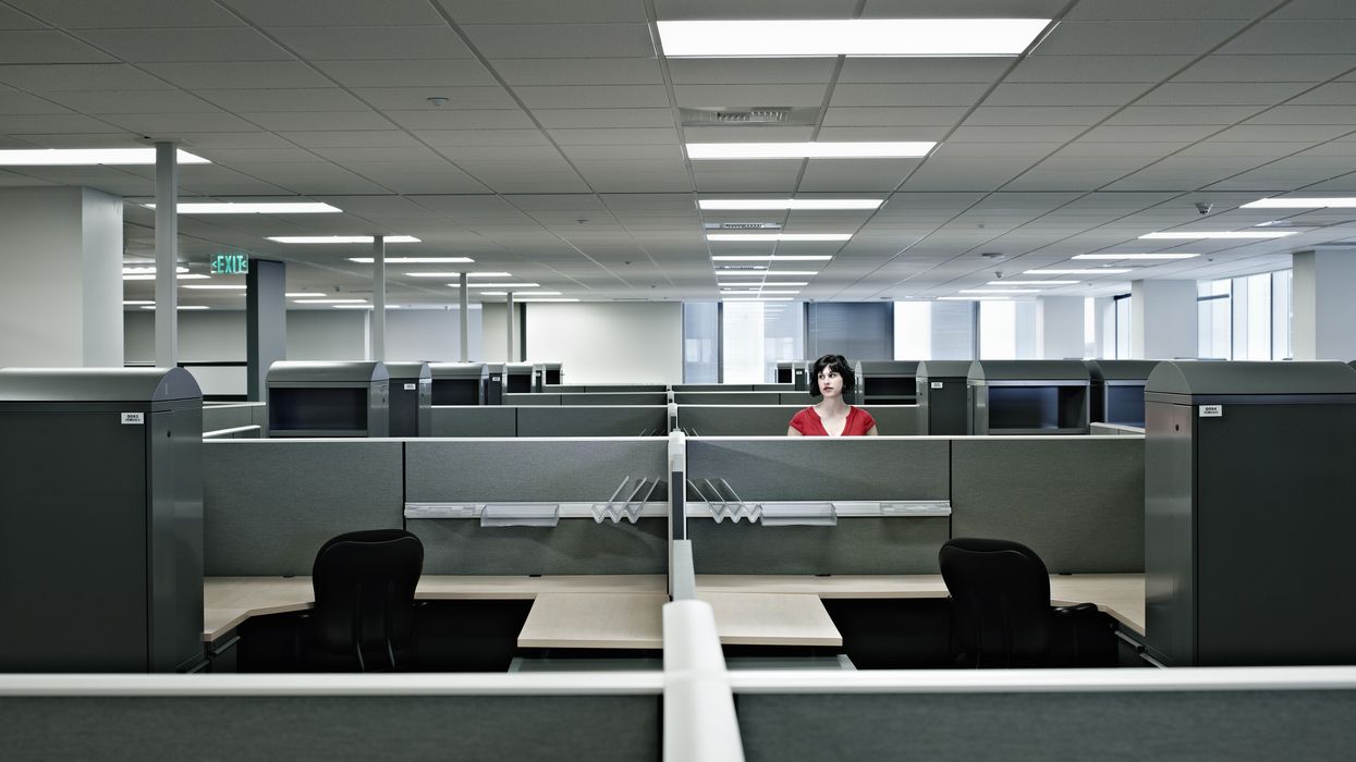 A worker standing alone in an office