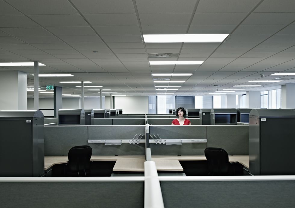 A worker standing alone in an office