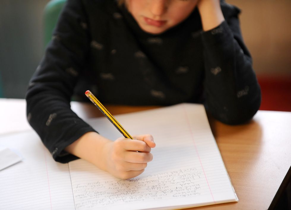 A young boy writing in a book