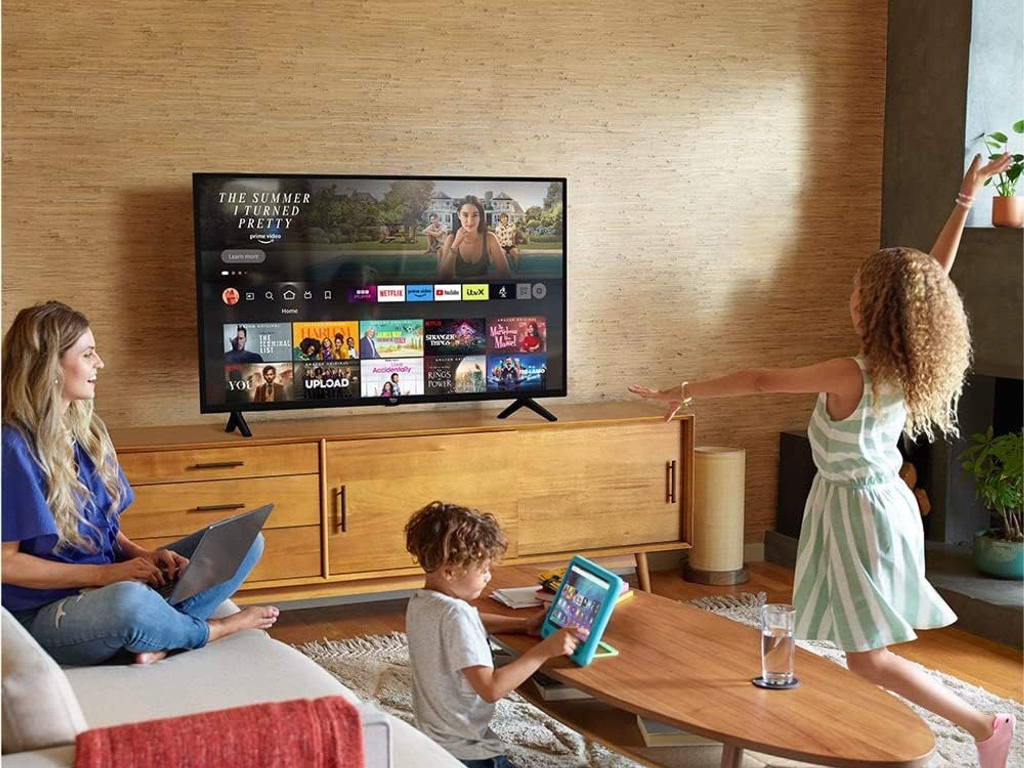 a young family pictured in the living room watching fire tv 2-series