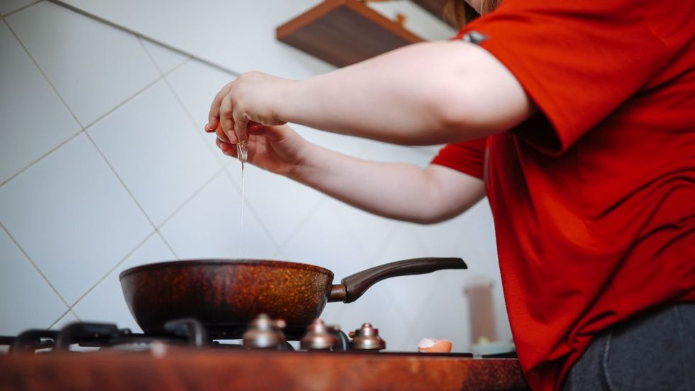 A young person cracking an egg