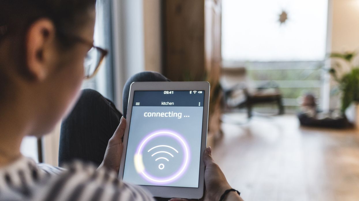 a young woman holds an ipad and tries to connect to a wireless internet connection