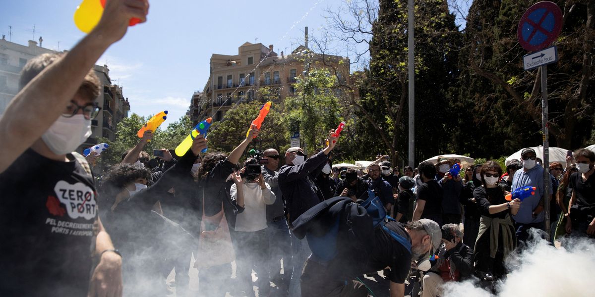NextImg:'Tourists go home!' Anti-tourist protesters SWARM tour bus and fire water pistols at holidaymakers
