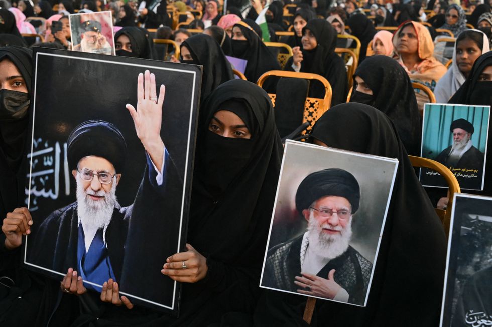 Activists carry portraits of Iran's slain supreme leader Ayatollah Ali Khamenei