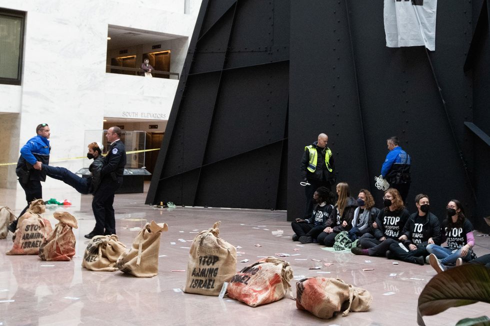 Activists engage in civil disobedience alongside Calder's Mountains and Clouds sculpture in the Hart Senate Office Building atrium
