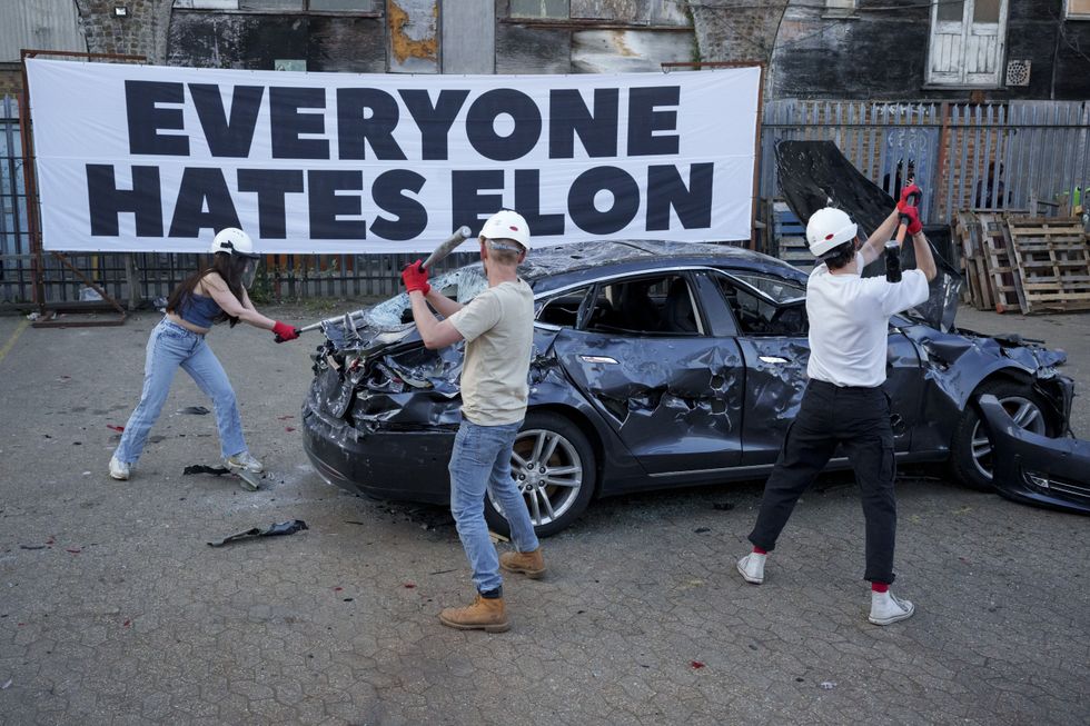 Activists protest against Elon Musk by smashing up a Tesla electric vehicle