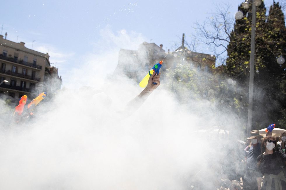 Activists stop a tourist bus with water pistols, in front of La Sagrada Familia Basilica