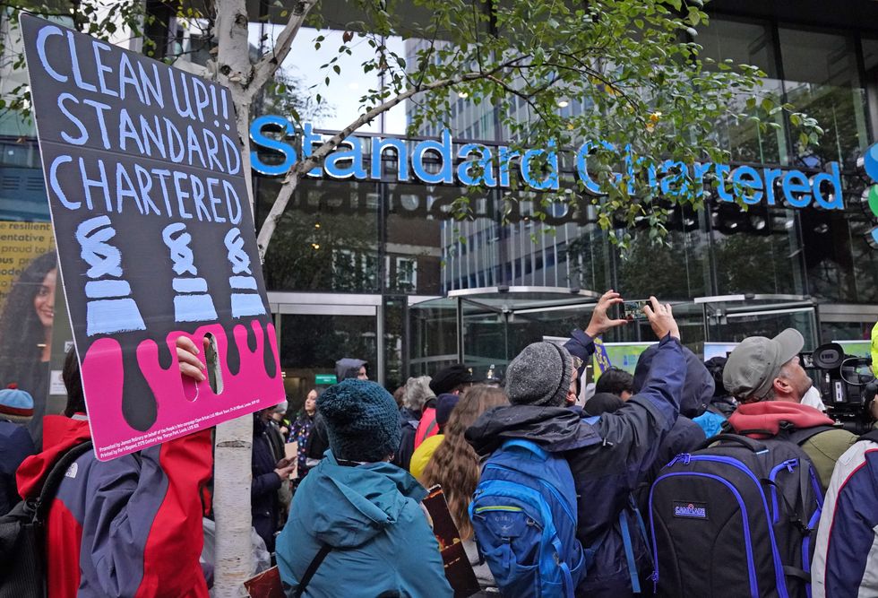 Activists take part in the Youth Strike to Defund Climate Chaos protest against the funding of fossil fuels outside Standard Chartered Bank in London.