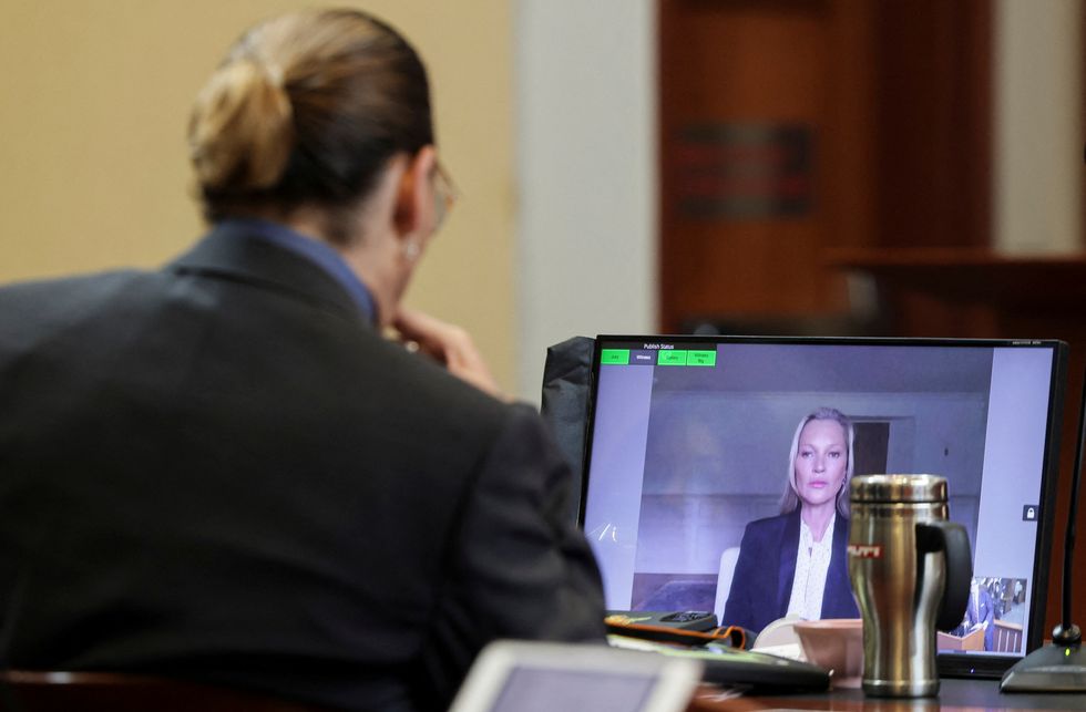 Actor Johnny Depp listens as his former girlfriend, Model Kate Moss testifies via video link during Depp's defamation trial against his ex-wife Amber Heard, at the Fairfax County Circuit Courthouse in Fairfax, Virginia, U.S., May 25, 2022. REUTERS/Evelyn Hockstein/Pool