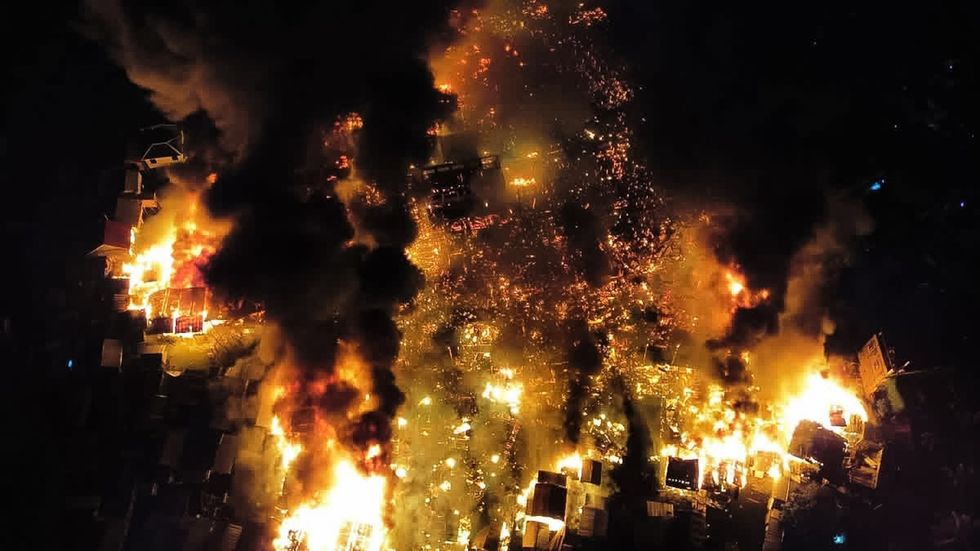 Aerial footage captured online reveals the sheer devastation, with rooftops engulfed in flames and structures collapsing into a sea of orange fire