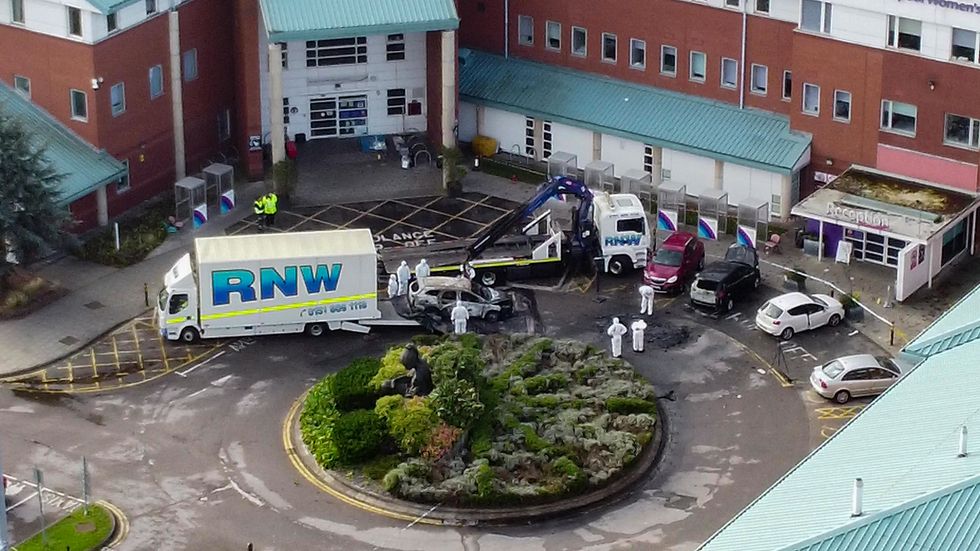 Aerial view of damaged car being removed by forensic officer after the explosion at the Liverpool Women's Hospital that killed one person and injured another on Sunday.