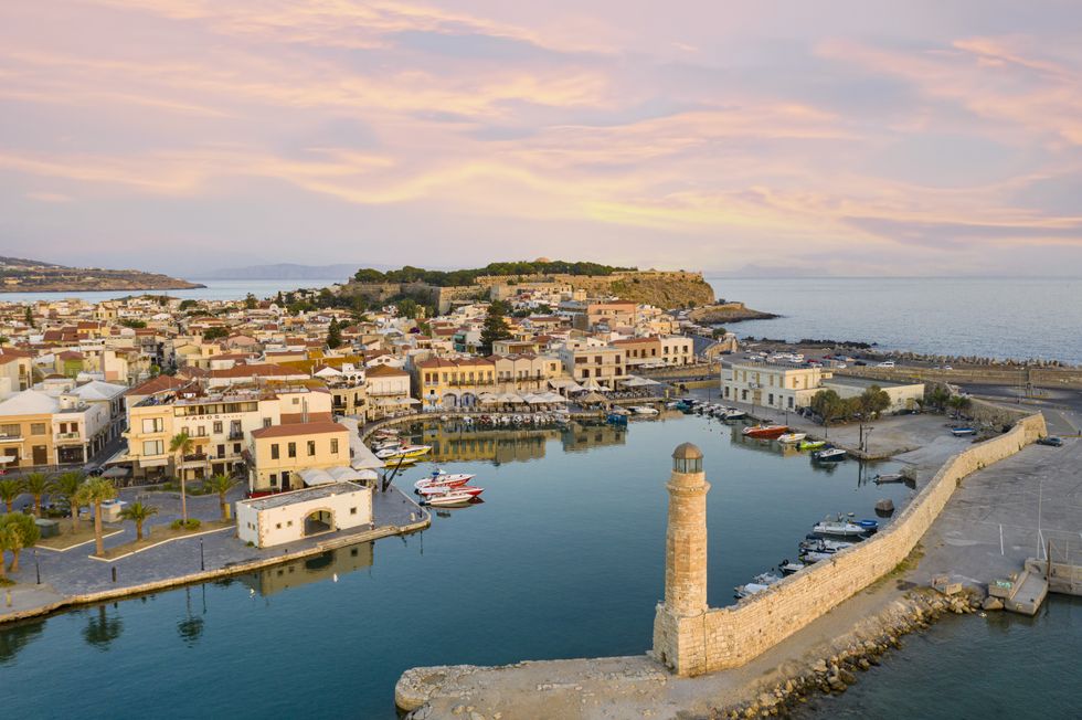 Aerial view of the old Venetian harbour and lighthouse at dawn, Rethymno, Crete island, Greece