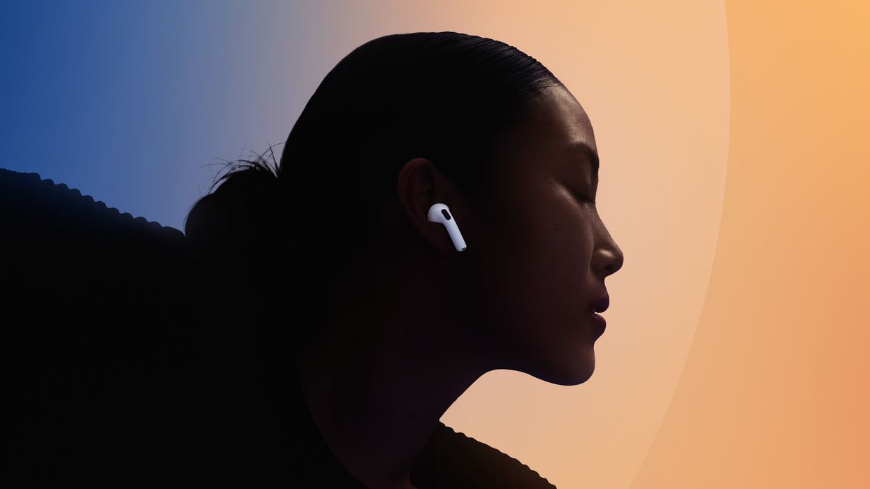 airpods 4 in someones ear with the colourful background