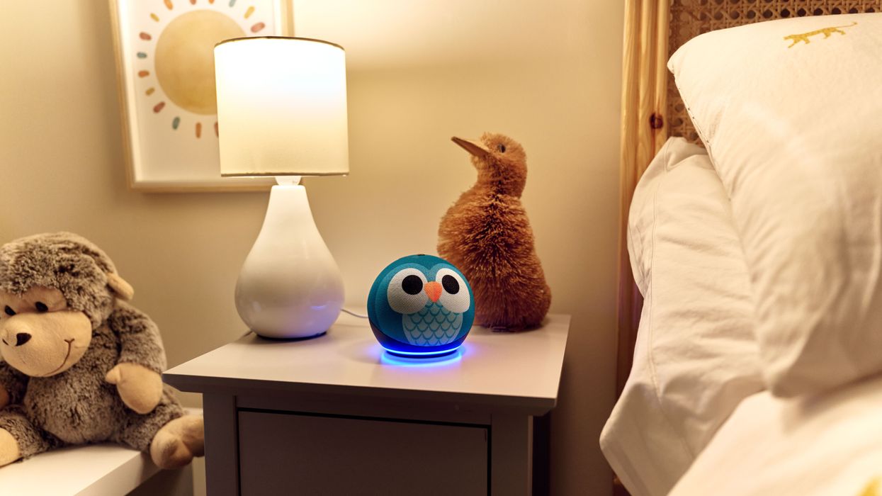 amazon echo kids edition speaker on a bedside table with cuddly toys surrounding it