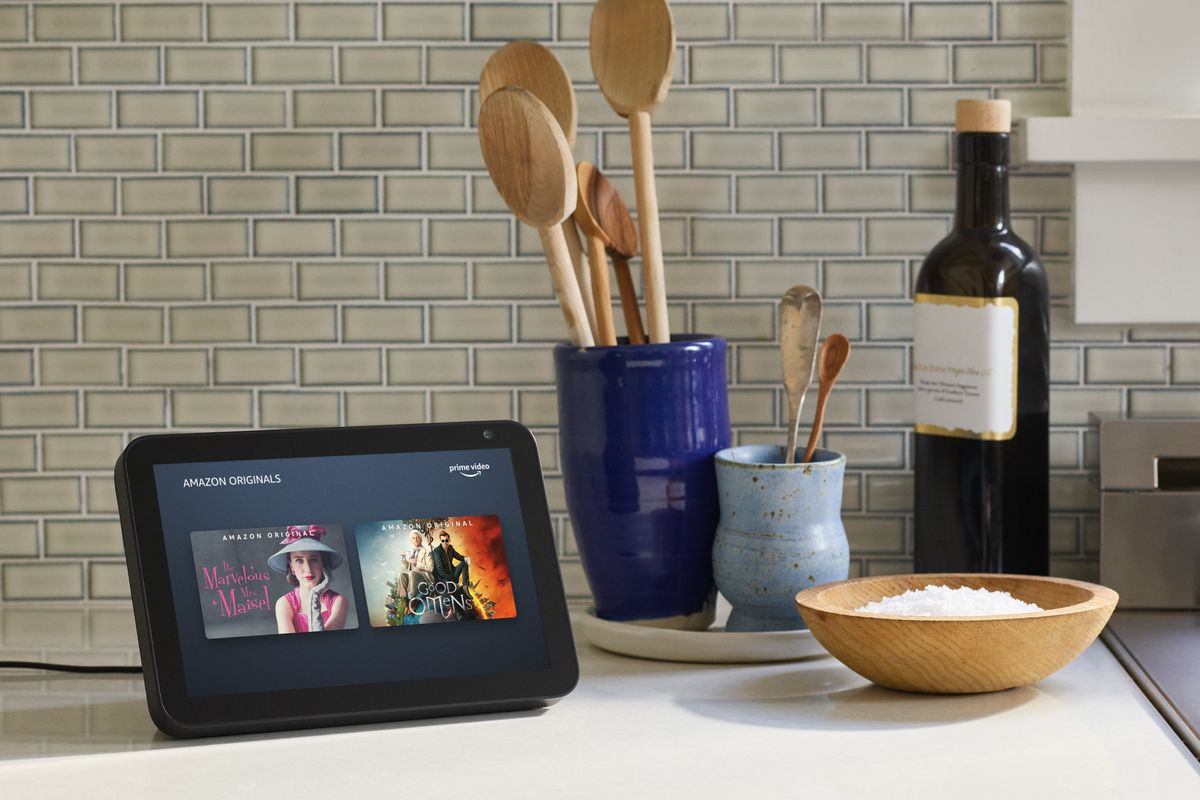 amazon echo show 5 pictured on a kitchen worktop with cooking utensils around it 